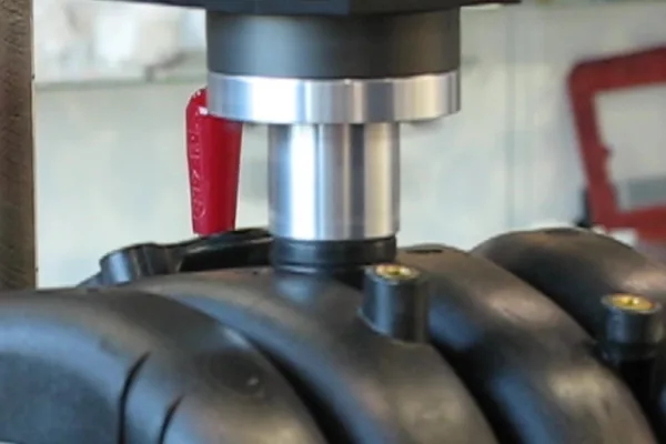 A spin welding spindle lowered onto a moulded intake manifold.